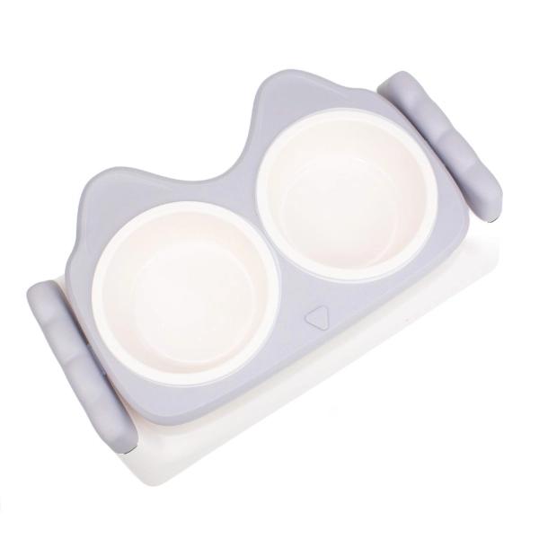 Imagen que muestra el producto Comedero Elevado Con Sistema De Inclinación. Comedero doble elevado con orejas, cuenta con sistema para ajustar la inclinación del comedero. Material: Plástico Color: Rosado, gris Disponible: Razas pequeñas