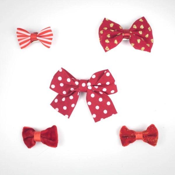 Imagen que muestra el producto Set X 5 Moños De Pinzas Para Mascotas. Set de moños en pinza para mascotas. Material: Poliéster, metal Color: Disponible en la foto Disponible: Razas medianas y grandes.